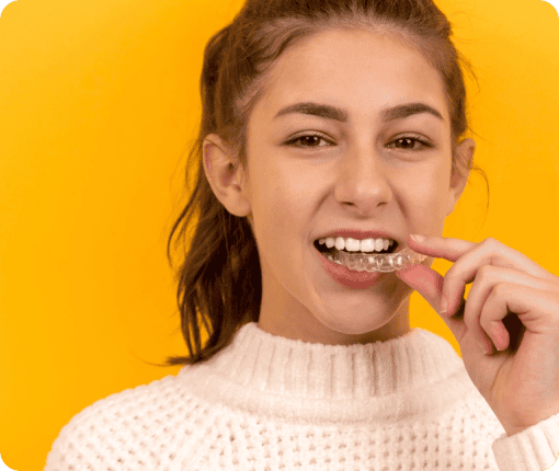 A headshot of a person trying Invisalign aligners.